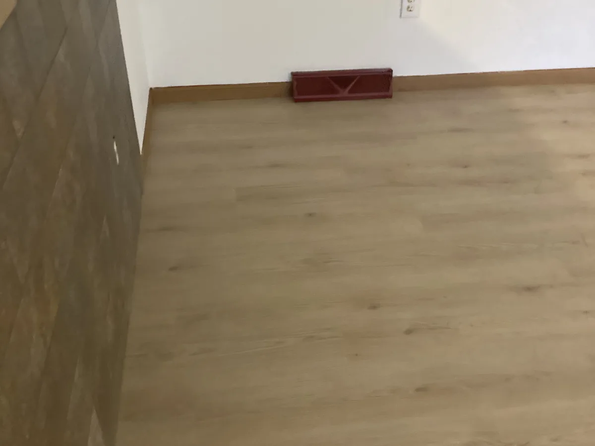 Completed light vinyl plank flooring in an empty room