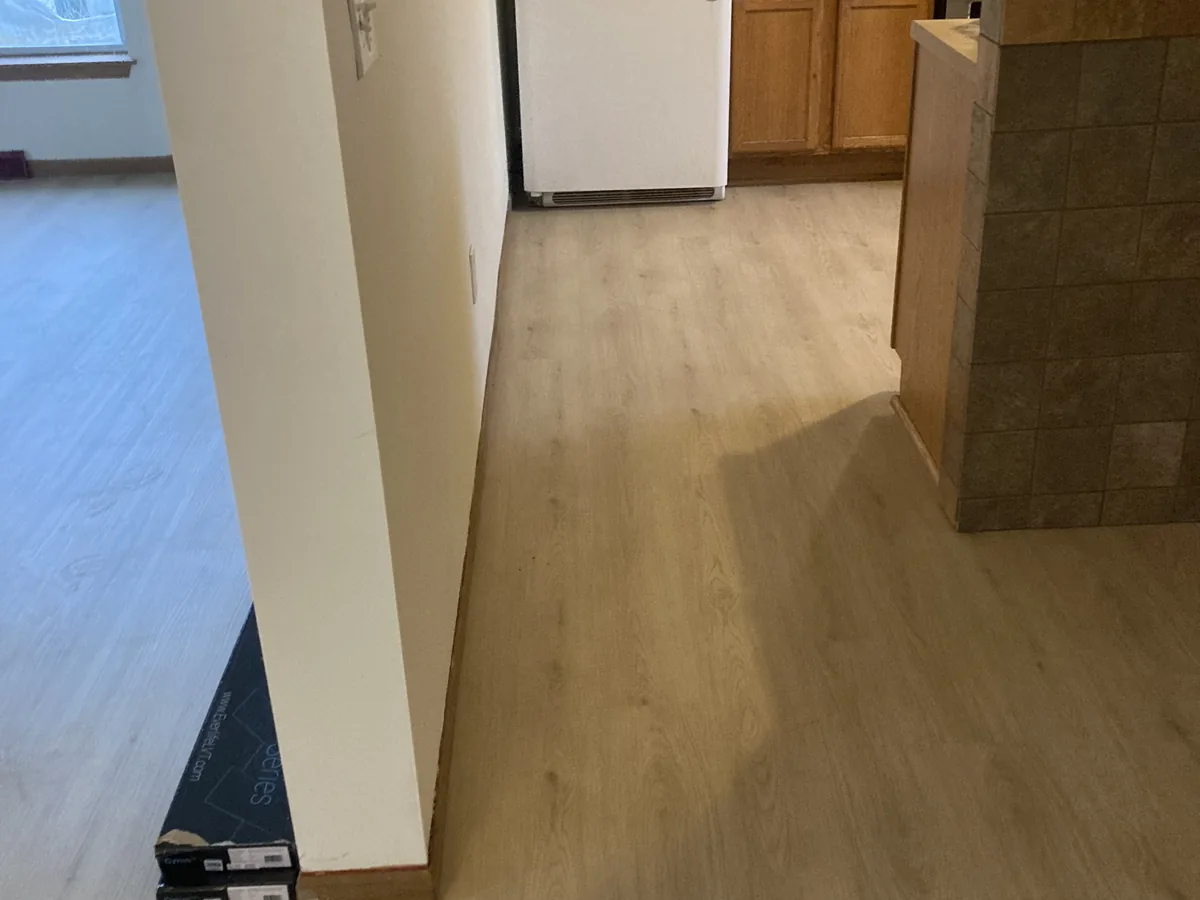 Finished vinyl plank flooring in a hallway leading into a Milwaukee kitchen